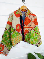 Stevie style revival kantha jacket #2302, in orange and green patchwork kantha on a hanger, front view