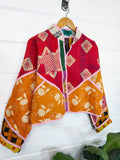 Stevie style revival kantha jacket #2303, in red and orange kantha on a hanger, front view