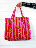 Pink Red Tiger print quilted tote bag, held up by hand, front view