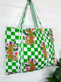 Green Checkered Jaguar print quilted tote bag, hanging on a wall, angled view