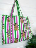 Pink and Green Jaguar print quilted tote bag, hanging on a wall, angled view