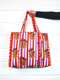 Orange and Purple Jaguar print quilted tote bag, held up by hand, front view